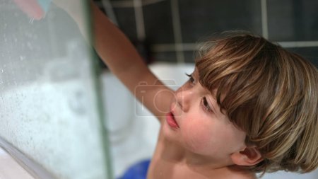 Téléchargez les photos : Enfant s'adonnant à une activité ludique seul dans la baignoire, vue de la routine amusante du bain - en image libre de droit