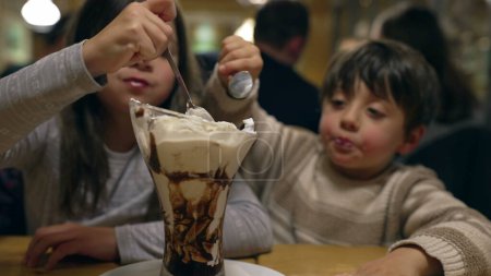 Photo for Children indulging in ice cream sundae with whipped cream. brother and sister enjoy dessert - Royalty Free Image