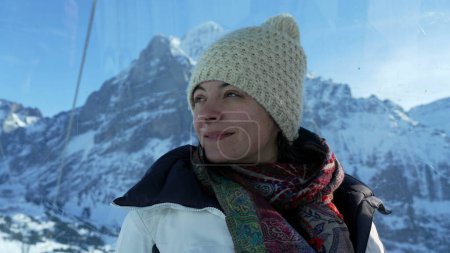 Téléchargez les photos : Femme vêtue de vêtements d'hiver profitant de la vue sur les Alpes suisses depuis le sommet de la montagne en regardant la vue panoramique - en image libre de droit