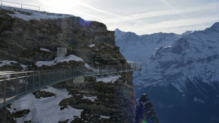 Téléchargez les photos : Swiss Alpine mountain view with elevé metal walkway along cliffside trail in Grindelwald Première vue sur les montagnes couvertes de neige - en image libre de droit