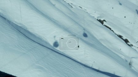 Foto de Múltiples remontes transportan sombras vistas desde lo alto de la montaña cubiertas de nieve durante la temporada de esquí - vistas desde el punto de vista del pasajero - Imagen libre de derechos