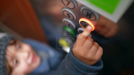Foto de Mano del niño presionando el botón del sexto piso dentro del ascensor. Niño subiendo al ascensor, ascendiendo - Imagen libre de derechos