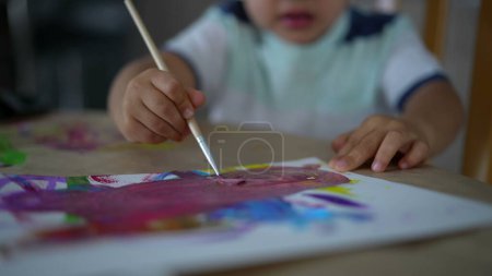 Foto de Primer plano niño mano usando pincel con acuarela pintura abstracta obra de arte - Imagen libre de derechos