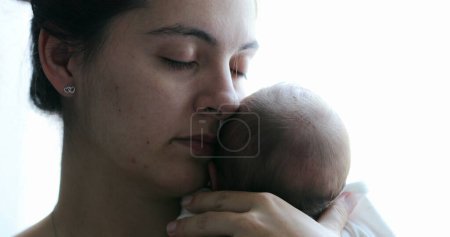 Foto de Mom holding newborn baby son in her arms, real life and candid family moment - Imagen libre de derechos