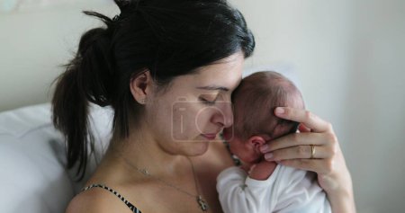 Foto de Mom holding newborn baby showing love and affection - Imagen libre de derechos