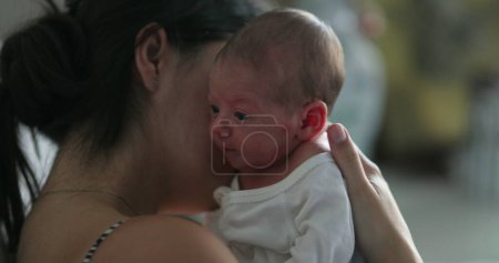 Foto de Mother holding tiny newborn frafile infant during first week of life - Imagen libre de derechos