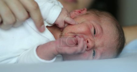 Photo for Newborn baby infant crying laying in bed, close-up of baby face crying - Royalty Free Image