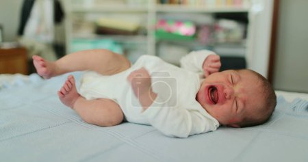 Téléchargez les photos : Newborn baby in bed awake stretching waking up - en image libre de droit