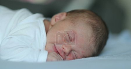 Photo for Newborn baby infant laying in bed being adorable and cute - Royalty Free Image