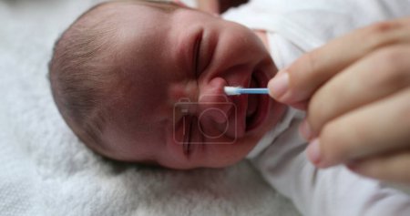 Photo for Cleaning newborn baby nose with swab - Royalty Free Image