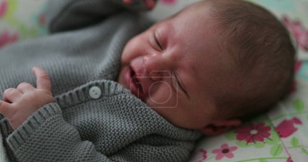 Photo for Tired Crying sleepy newborn baby infant first month old - Royalty Free Image