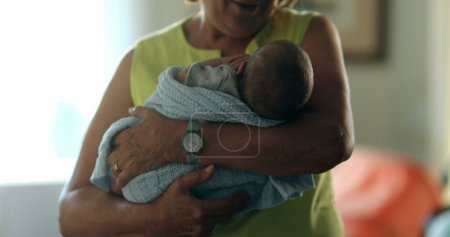 Téléchargez les photos : Happy grand-mother holding newborn baby infant in arms feeling joy - en image libre de droit