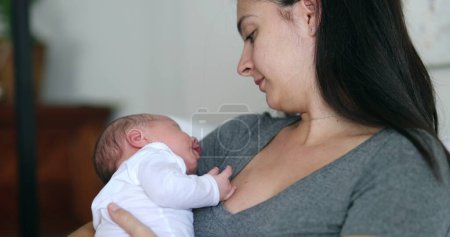 Foto de Mother holding newborn baby during first month of life casual and candid real life - Imagen libre de derechos