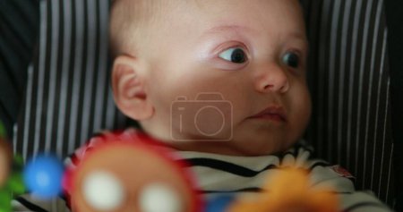 Téléchargez les photos : Baby infant newborn seated in baby chair rocker with toys - en image libre de droit