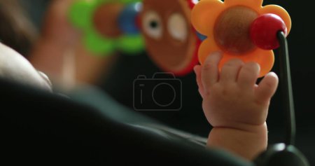 Téléchargez les photos : Baby hands playing with toy inside chair crib - en image libre de droit