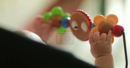 Téléchargez les photos : Baby hands playing with toy inside chair crib - en image libre de droit