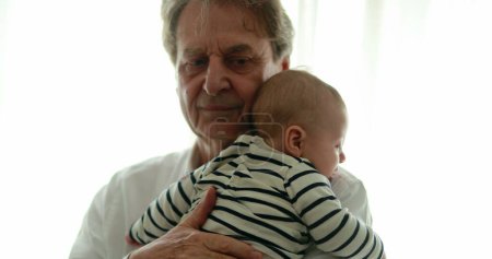 Foto de Auténtico abuelo sosteniendo nieto bebé bebé - Imagen libre de derechos
