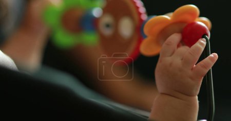 Téléchargez les photos : Closeup of infant baby hands playing with spinning toy - en image libre de droit