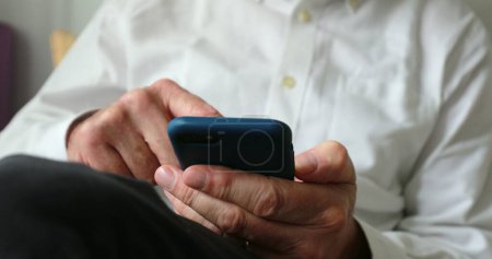 Téléchargez les photos : Older man using cellphone device - en image libre de droit