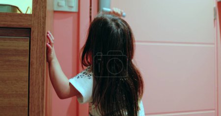 Foto de Niña niña apertura puerta pomo y cierre - Imagen libre de derechos