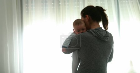Photo for Revealing mother holding baby infant newborn at home good for transition - Royalty Free Image