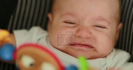 Photo for Upset baby infant doing grimace unhappy in chair - Royalty Free Image