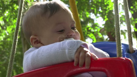 Téléchargez les photos : Bébé garçon au parc de jeux swing - en image libre de droit