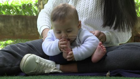 Téléchargez les photos : Bébé découvrant pied bébé mettant les pieds dans la bouche - en image libre de droit
