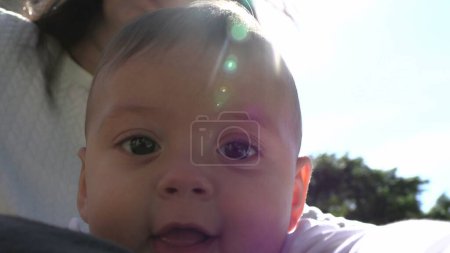 Foto de Adorable retrato de la cara del bebé afuera con destello de lente - Imagen libre de derechos