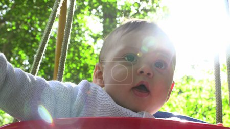 Téléchargez les photos : Bébé garçon mignon jouant au parc de swing de terrains de jeux - en image libre de droit