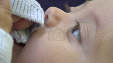 Téléchargez les photos : Gros plan de bébé mordant manchon à mâcher tissu - en image libre de droit
