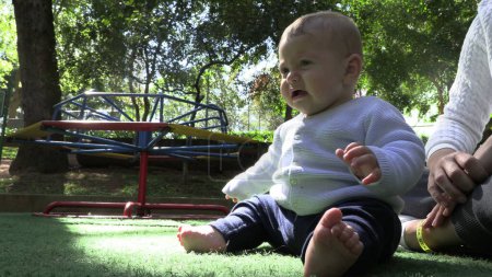 Foto de Molesto bebé infante insatisfecho sentado en el parque - Imagen libre de derechos