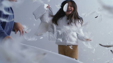 Photo for Happy Siblings in Feather-Filled Fun - Bed Bounce and Pillow Fight in Super Slow Motion at 1000 FPS - Royalty Free Image