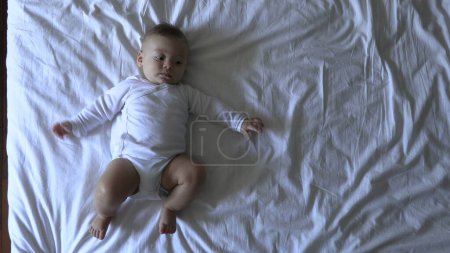 Photo for Cute baby infant boy in bed - Royalty Free Image