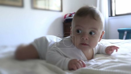Téléchargez les photos : Bébé bébé mignon se réveillant le matin en s'amusant au lit - en image libre de droit