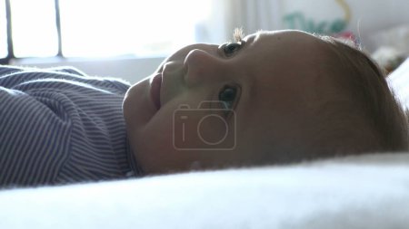 Photo for Baby toddler layed in bed observing - Royalty Free Image