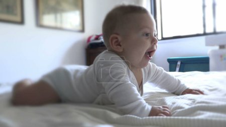 Téléchargez les photos : Bébé bébé mignon se réveillant le matin en s'amusant au lit - en image libre de droit