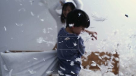 Téléchargez les photos : Enfance sans soucis - Les enfants dans la bataille d'oreillers remplis de plumes, capturé à 1000 FPS - en image libre de droit