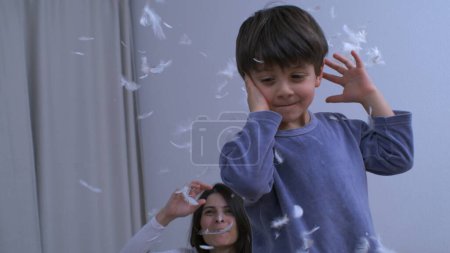 Photo for Authentic Joy - Mother, Daughter, and Son Playing with Pillow Feathers - Royalty Free Image