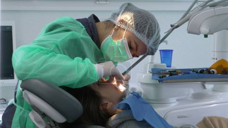 Zahnärztin, die in der Zahnklinik arbeitet. Konzentrierte Fachkraft kümmert sich um die Mundgesundheit von Kindern