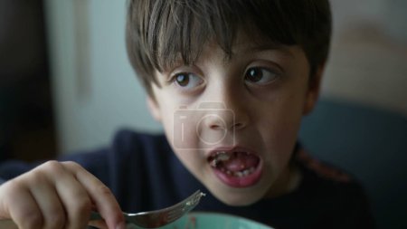 Téléchargez les photos : Petit garçon mangeant des gnocchis, gros plan d'un repas pensif de cinq ans - en image libre de droit