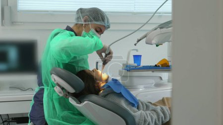 Konzentrierte Zahnärztin, die Kinderzähne in der Klinik behandelt. Berufstätige
