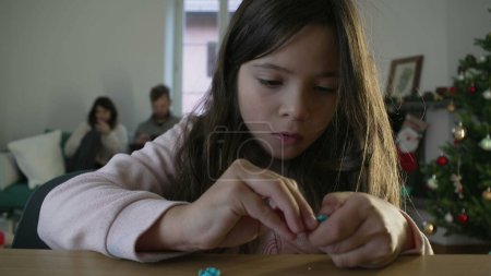 Photo for Concentrated little girl assembling toy. female child putting object together engrossed in play by herself, childhood leisure activity - Royalty Free Image