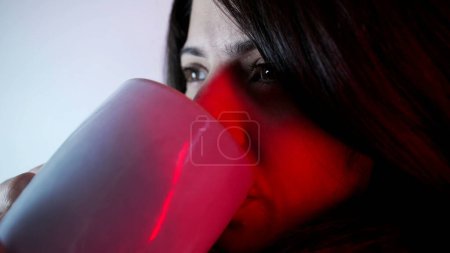 Photo for Pensive close-up woman drinking hot tea. Thoughtful gaze of person having leisure activity during cold weather - Royalty Free Image