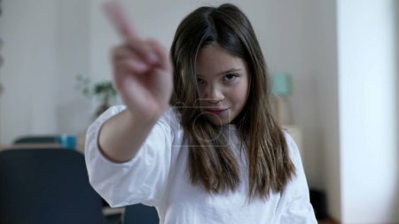 Child waves finger to camera saying NO, one little 8 year old girl in REJECTION