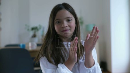 Téléchargez les photos : Enfant applaudissements mains, une petite fille montrant félicitations - en image libre de droit