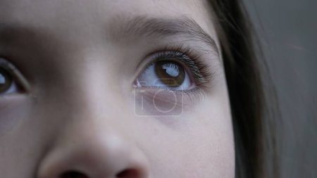 Foto de Macro primer plano de los ojos del niño mirando hacia arriba, característica de la vista facial de niño de 8 años mira hacia arriba en la contemplación - Imagen libre de derechos