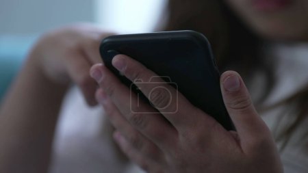 Photo for Close-up child's hands holding cellphone device. Kid using modern technology staring at phone screen browsing social media - Royalty Free Image