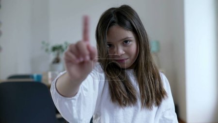 Photo for Child waves finger to camera saying NO, one little 8 year old girl in REJECTION - Royalty Free Image