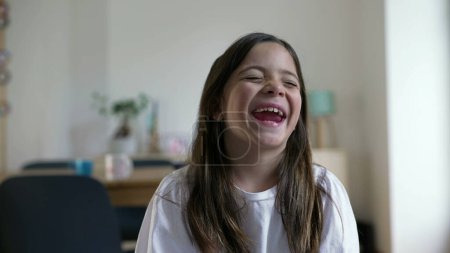 Photo for One happy little girl bursts laughing out loud. Close-up child face feeling joy in carefree moment, authentic real life laugh and smile - Royalty Free Image